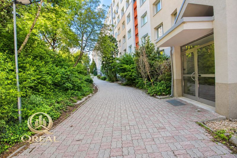  3-izbový byt Karlova Ves – Dlhé diely, 75,79 m², možnosť garáže* - Chodník pri bytovom dome na Hlaváčikovej ulici v Bratislave, Karlova Ves, obklopený zeleňou.