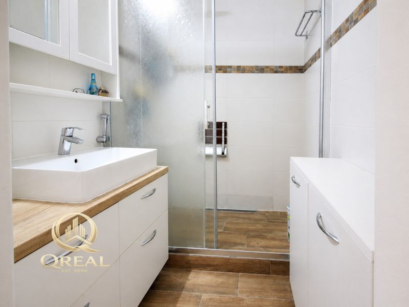  3-izbový byt Karlova Ves – Dlhé diely, 75,79 m², možnosť garáže* - Kúpeľňa v 3-izbovom byte s umývadlom, sprchovým kútom a podlahou s dreveným dekorom.