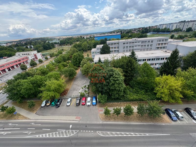 Na predaj Garsônka, 24,5 m2, s perfektnou polohou.  - Pohľad na parkovisko, zeleň a budovu z výšky na Novomeského, Nitra - Klokočina.