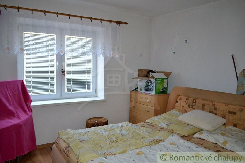 Dom so zrekonštruovaným interiérom - Varadka - Spálňa v rodinnom dome s posteľou, komodou a oknom so žalúziami.