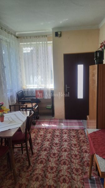 GAZDOVSKÝ DOM so záhradou a humnom, Ostrá Lúka pri Zvolene - Interiér rodinného domu s drevenými dverami, stolom, stoličkami a koberecom.