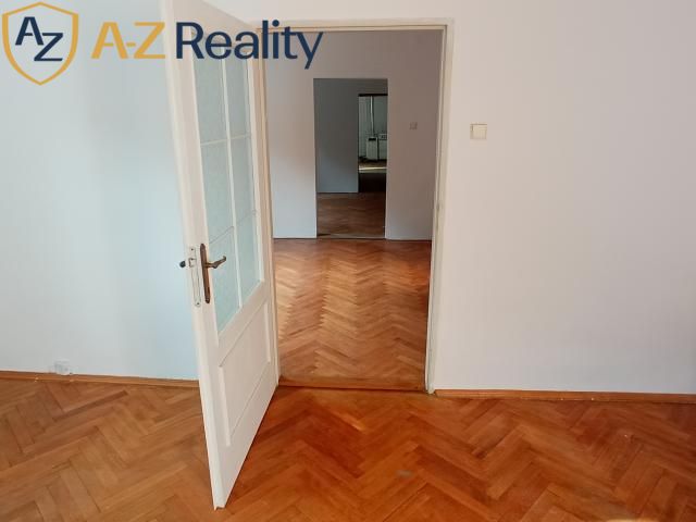 2 budovy v centre Komárna na predaj! - Interiér rodinného domu s podlahou s dreveným dekorom a otvorenými dverami medzi miestnosťami.