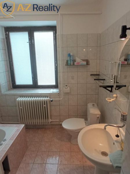 2 budovy v centre Komárna na predaj! - Kúpeľňa v rodinnom dome s vaňou, umývadlom, zrkadlom a oknom s tienidlom.