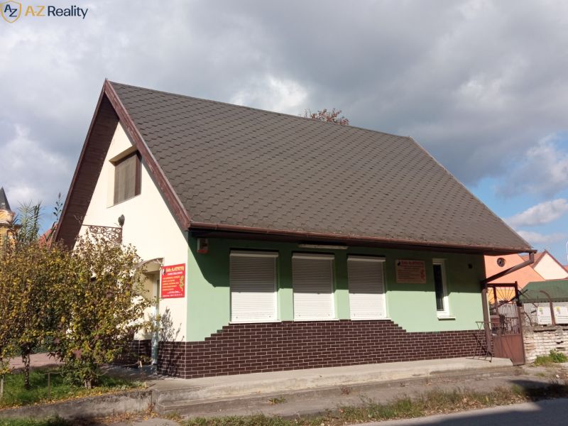 2 budovy v centre Komárna na predaj! - Rodinný dom v Komárne so šikmou strechou a zeleno-hnedou fasádou.