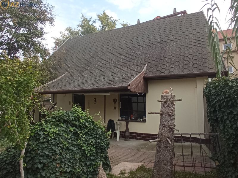 2 budovy v centre Komárna na predaj! - Rodinný dom v Komárne so sedlovou strechou obklopený zeleňou a dláždeným chodníkom.