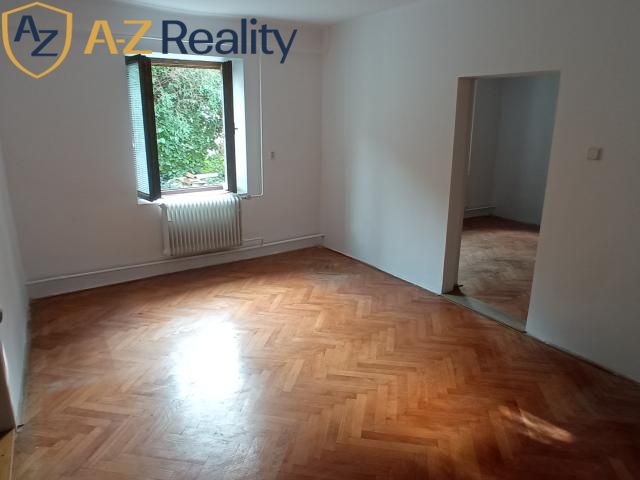 2 budovy v centre Komárna na predaj! - Izba v rodinnom dome s podlahou s dreveným dekorom a oknom do záhrady.