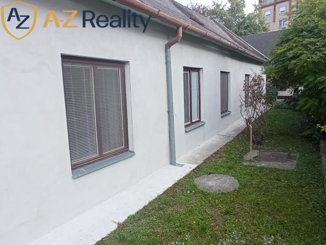 2 budovy v centre Komárna na predaj! - Rodinný dom na Vnútornej okružnej v Komárne s bielou fasádou a malou záhradou.