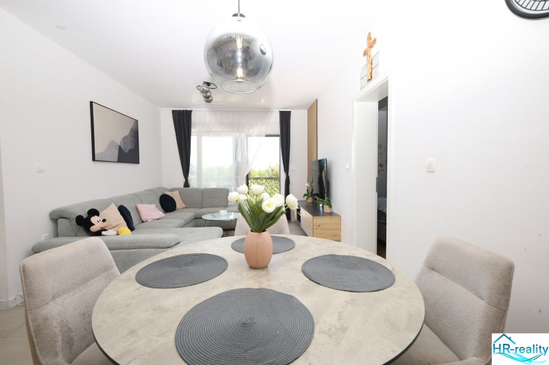 Chorvátsko, Vodice - zariadený apartmán s výhľadom na more - Rekreačný apartmán s pohodlnou sedačkou, jedálenským stolom a dekoráciou v interiéri.