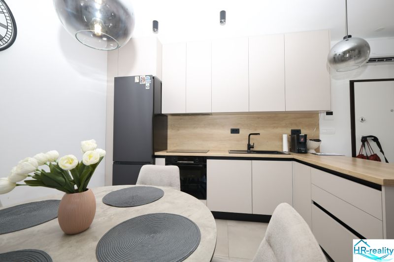 Chorvátsko, Vodice - zariadený apartmán s výhľadom na more - Kuchyňa v rekreačnom apartmáne so zabudovanými spotrebičmi a jedálenským stolom s dekoračnými doplnkami.