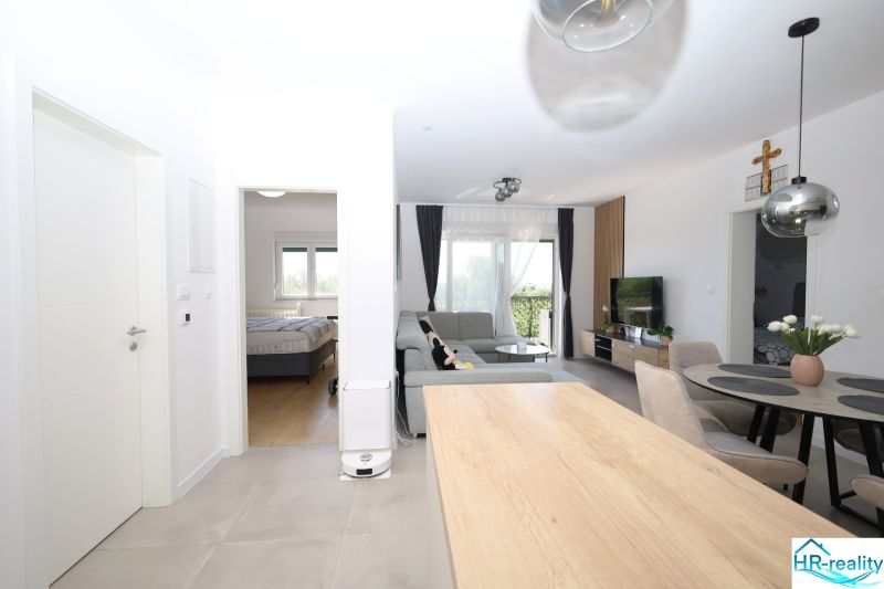 Chorvátsko, Vodice - zariadený apartmán s výhľadom na more - Otvára sa výhľad na svetlú obývačku s kuchyňou a jedálňou v rekreačnom apartmáne.