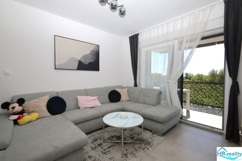 Chorvátsko, Vodice - zariadený apartmán s výhľadom na more - Svetlá obývačka s rohovou sedačkou v Rekreačnom apartmáne.
