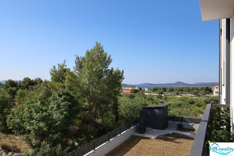Chorvátsko, Vodice - zariadený apartmán s výhľadom na more - Výhľad z rekreačného apartmánu vo Vodiciach, zahŕňajúci zeleň a pohorie v diaľke.