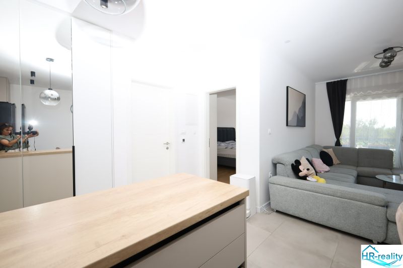 Chorvátsko, Vodice - zariadený apartmán s výhľadom na more - Obývacia izba v Rekreačnom apartmáne s pohodlnou sedačkou a výhľadom cez veľké okno.