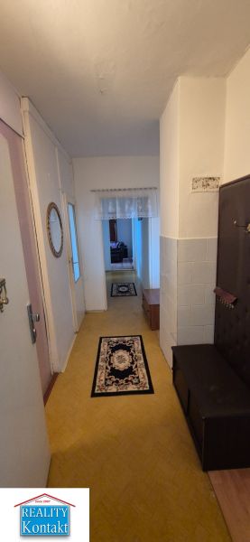 Na predaj 2 izbový byt 62m2 s 3 balkónmi - Nové Zámky  - Chodba v 2-izbovom byte s podlahou s dreveným dekorom a kobercami.