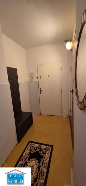Na predaj 2 izbový byt 62m2 s 3 balkónmi - Nové Zámky  - Chodba s vešiakovou stenou, zrkadlom a kobercom v 2-izbovom byte.