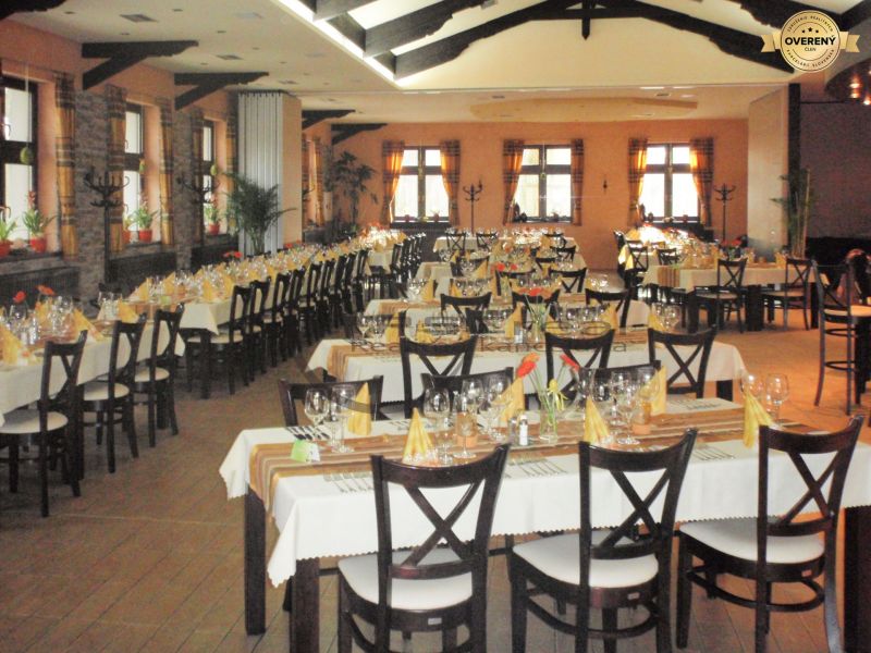 NA PREDAJ jedinečný gastro eventový areál v lesoparku Berek Nové Zámky - Gastro priestory s elegantne prestretými stolmi a podlahou s dreveným dekorom.