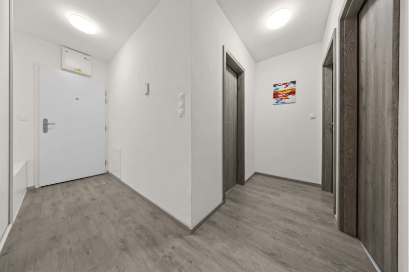 NA PREDAJ: 3-izbový apartmán, MATADORKA, Bratislava - Petržalka - Chodba so stenami v bielej farbe a podlahou s dreveným dekorom v 3-izbovom byte.