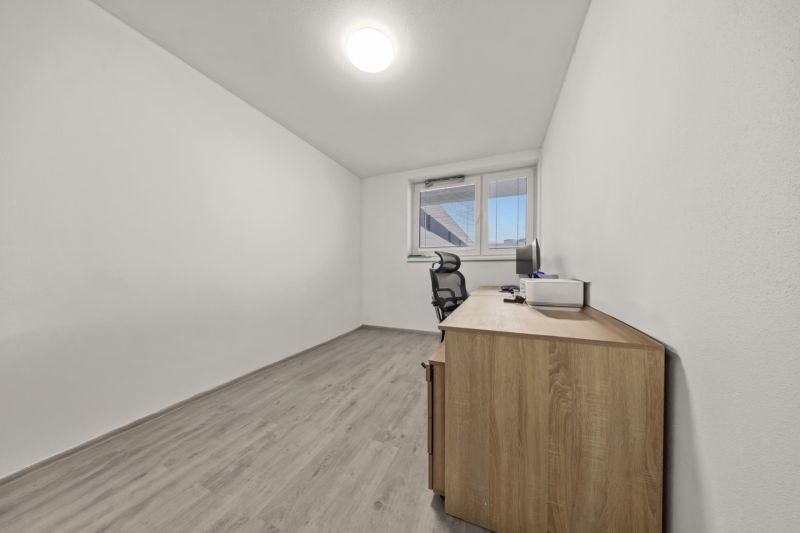 NA PREDAJ: 3-izbový apartmán, MATADORKA, Bratislava - Petržalka - Minimalistická pracovňa s kancelárskym stolom a stoličkou v 3-izbovom byte, podlaha s dreveným dekorom.