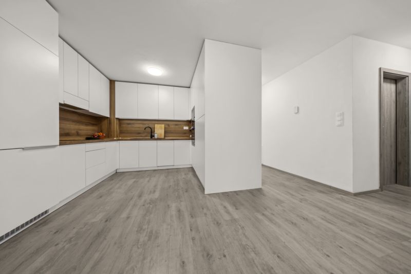 NA PREDAJ: 3-izbový apartmán, MATADORKA, Bratislava - Petržalka - Kuchyňa v 3-izbovom byte s bielymi skrinkami a podlahou s dreveným dekorom.