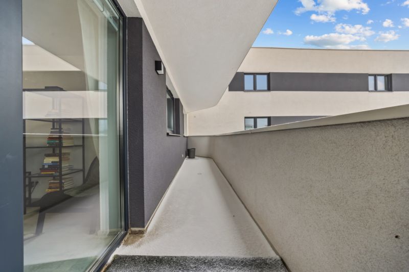 NA PREDAJ: 3-izbový apartmán, MATADORKA, Bratislava - Petržalka - Balkón s výhľadom na vedľajší dom, vidno aj interiér 3-izbového bytu s knihovničkou.