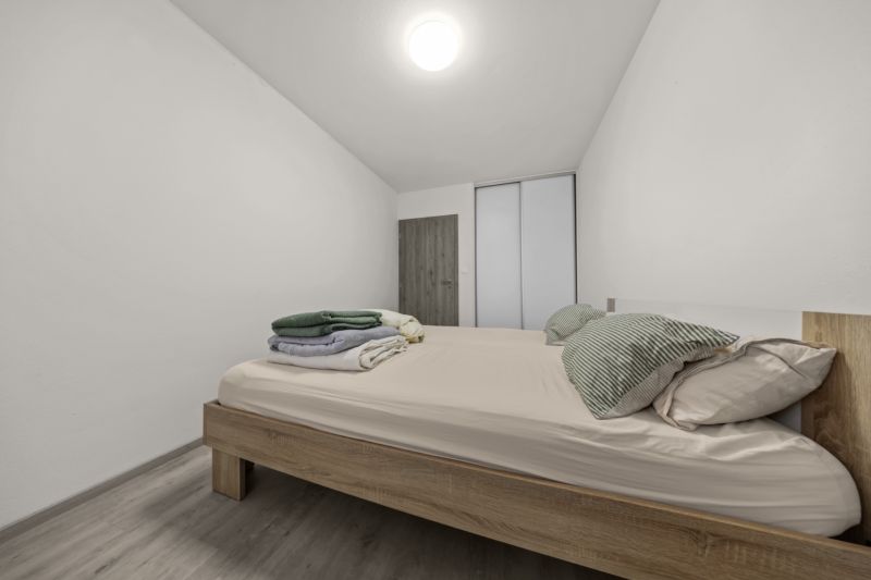 NA PREDAJ: 3-izbový apartmán, MATADORKA, Bratislava - Petržalka - Spálňa so svetlými stenami, posteľou s obliečkami a podlahou s dreveným dekorom v 3-izbovom byte.