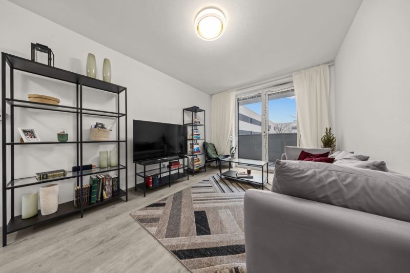 NA PREDAJ: 3-izbový apartmán, MATADORKA, Bratislava - Petržalka - Obývacia izba s podlahou s dreveným dekorom, pohovkou a policami v 3-izbovom byte.