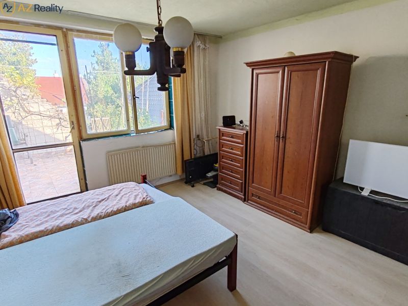 Rodinný dom na predaj Komárno - Spálňa v rodinnom dome s posteľou a šatníkovou skriňou.