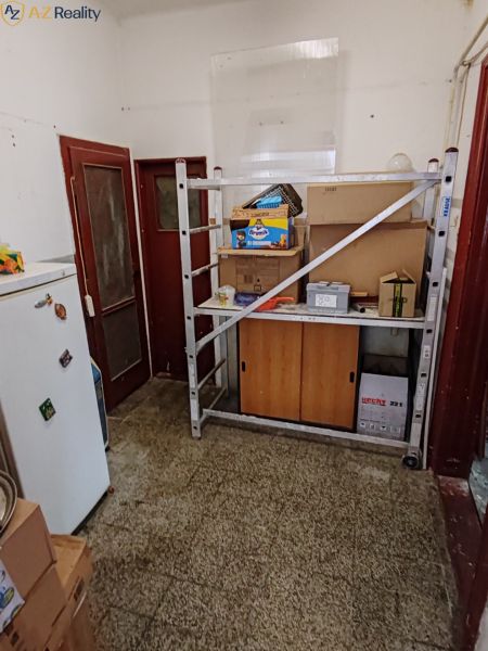 Rodinný dom na predaj Komárno - Perspektíva miestnosti s regálom a kartónmi v rodinnom dome.