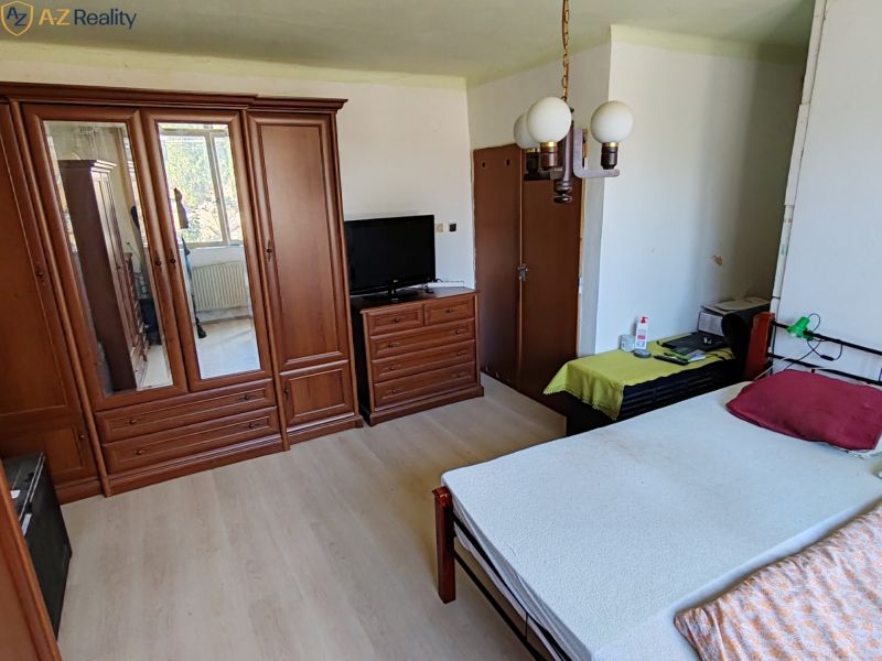 Rodinný dom na predaj Komárno - Spálňa v rodinnom dome s dreveným nábytkom a podlahou s dreveným dekorom.