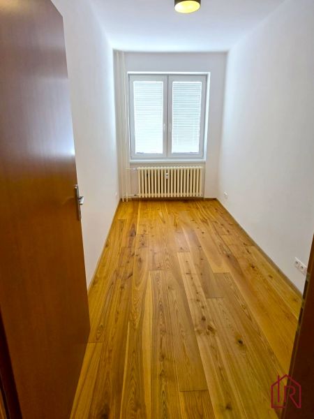 NA PRENÁJOM 4 izbový byt s loggiou, Veľký Šariš - Izba s podlahou s dreveným dekorom a oknom v 4-izbovom byte.