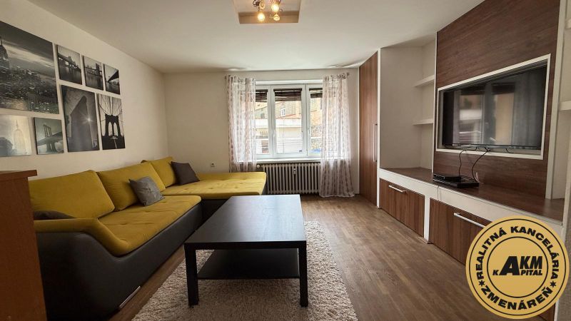1 izbový 30m2 slnečný byt Zvolen centrum na PRENÁJOM ul. Študentská - Obývacia izba s rohovou sedačkou, televízorom a podlahou s dreveným dekorom, 1-izbový byt.