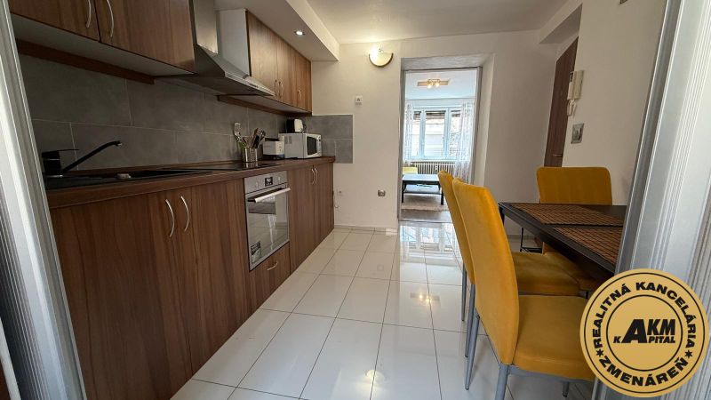 1 izbový 30m2 slnečný byt Zvolen centrum na PRENÁJOM ul. Študentská - Kuchyňa v 1-izbovom byte s dlažbou, dreveným dekorom a žltými stoličkami.