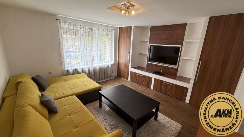 1 izbový 30m2 slnečný byt Zvolen centrum na PRENÁJOM ul. Študentská - Obývacia izba v 1-izbovom byte s veľkou žltou sedačkou, skrinkami a podlahou s dreveným dekorom.