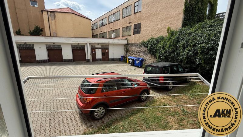 1 izbový 30m2 slnečný byt Zvolen centrum na PRENÁJOM ul. Študentská - Pohľad z okna na Študentskej ulici vo Zvolene ukazuje dvor s autami.