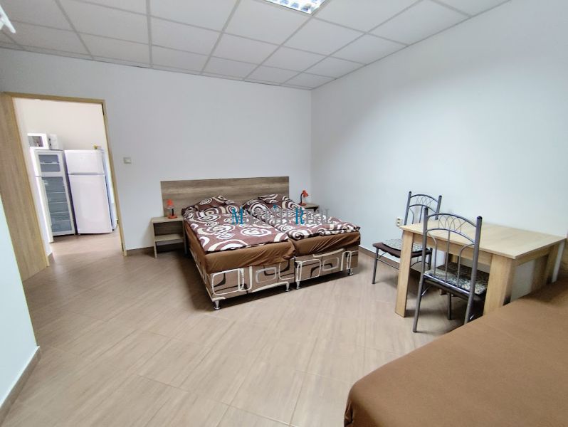 Na predaj zabehnutý ubytovací objekt – Privát - Podhájska - Izba v rodinnom dome s podlahou s dreveným dekorom, posteľami a stolom.