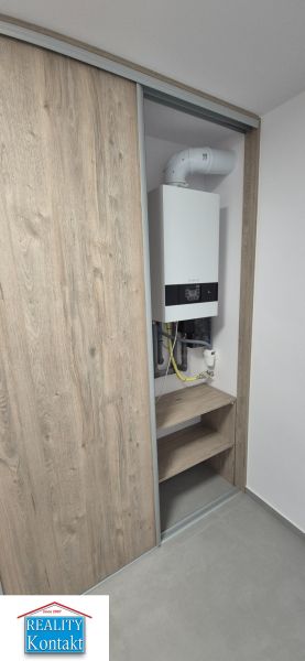 Na prenájom kompletne prerob. NOVÝ 2 izbový byt čiast.zar. Nové Zámky - Vstavaná skriňa v 2-izbovom byte s kotlom a podlahou s dreveným dekorom.