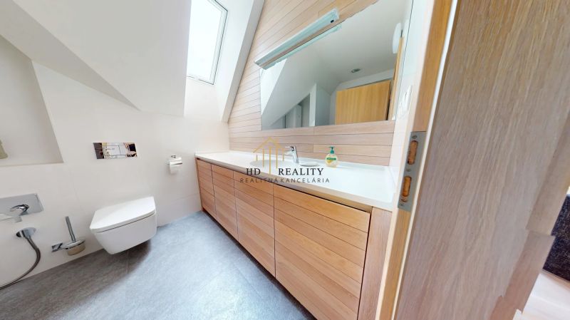 Pripravujeme do ponuky jedinečný apartmánový bytový dom Donovaly  - Kúpeľňa v chate s dreveným dekorom, vybavená umývadlom a veľkým zrkadlom.