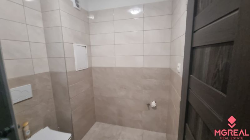 2-izbový moderný byt, s garážovým státím  novostavba, Coboriho ulica - Kúpeľňa so svetlými obkladmi a tmavými dverami v 2-izbovom byte.