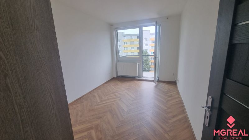 2-izbový moderný byt, s garážovým státím  novostavba, Coboriho ulica - Priestranná izba s francúzskym oknom a podlahou s dreveným dekorom v 2-izbovom byte.