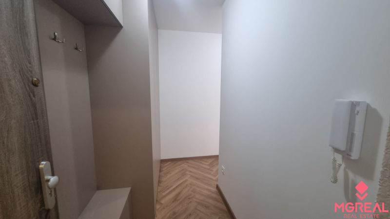 2-izbový moderný byt, s garážovým státím  novostavba, Coboriho ulica - Interiér 2-izbového bytu s podlahou s dreveným dekorom a bielymi stenami.