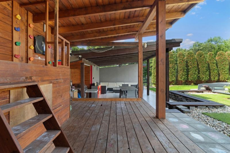 ARCHITEKTÚRA TICHA A MODERNÝCH TECHNOLÓGIÍ - SMART VILLA V OBJATÍ LESA - Drevená terasa rodinného domu na Záhradnej ulici v Lukavici s pohodlným posedením vonku.