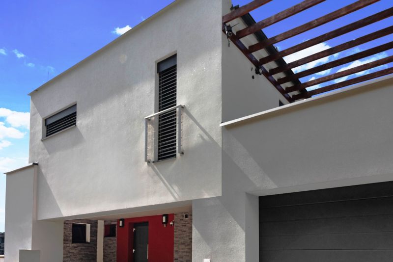 ARCHITEKTÚRA TICHA A MODERNÝCH TECHNOLÓGIÍ - SMART VILLA V OBJATÍ LESA - Rodinný dom na Záhradnej ulici v Lukavici so svetlou fasádou a drevenou pergolou.