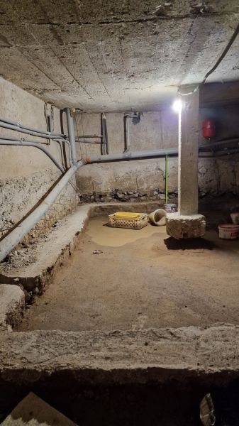 Rodinný dom s veľkorysou prístavbou v obci Parchovany - Pivničný priestor rodinného domu, stavebný materiál, potrubie a nádrž na ulici Staničná v Parchovanoch.