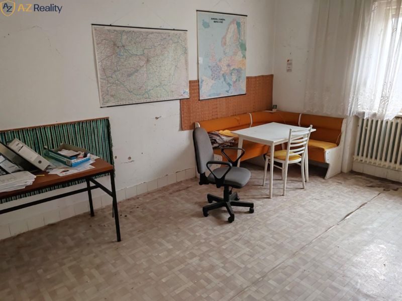 Ponúkame Rodinný dom vhodný na bývanie aj podnikanie - Izba v rodinnom dome s mapami, stolom, stoličkami a podlahou s dreveným dekorom.
