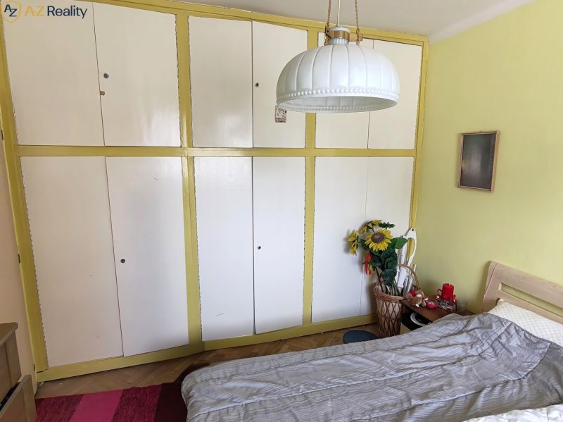 Znížená cena!   3 izbový byt na VII. sídlisku na predaj - Izba s posteľou, vstavanou skriňou, izbovými dekoráciami a stenou svetlej farby v 3-izbovom byte.