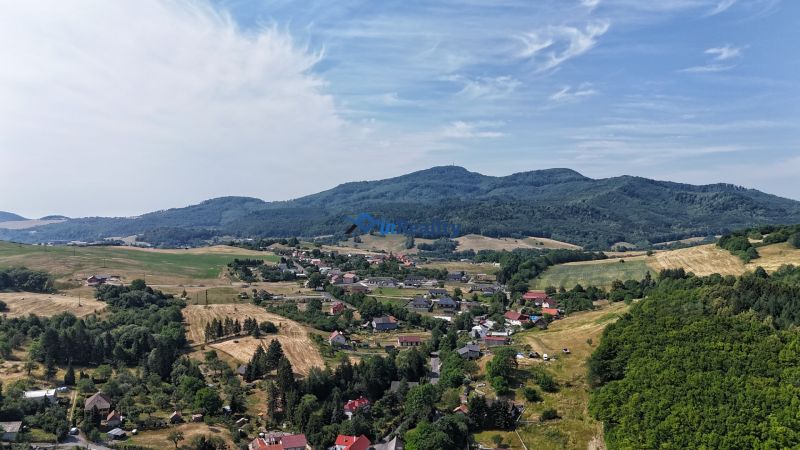 Objekt s historickým nádychom v Banskej Štiavnici - Štefultov - Krajina vidieka pri Štefultove, Banská Štiavnica, obklopená kopcami a poliami.