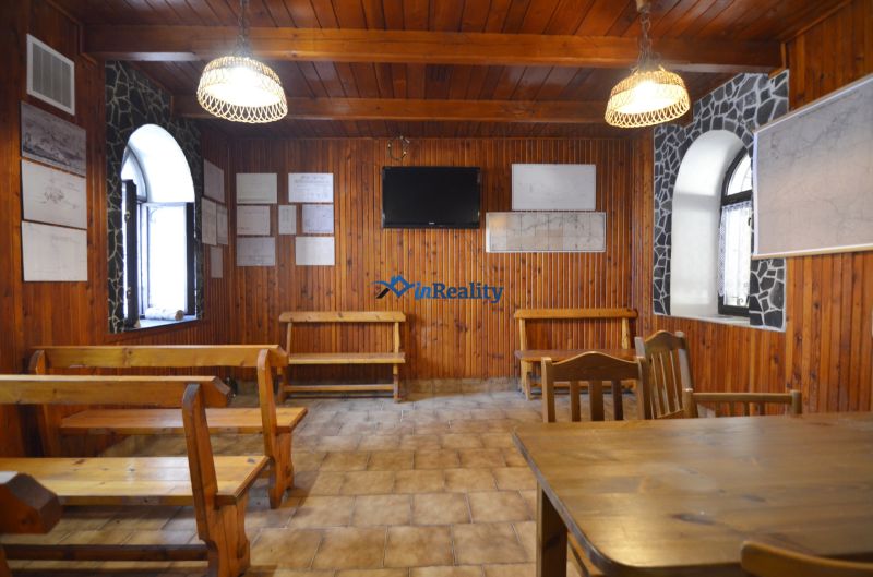 Objekt s historickým nádychom v Banskej Štiavnici - Štefultov - Interiér gastro priestorov s drevenými stenami, lavicami a televízorom na stene.