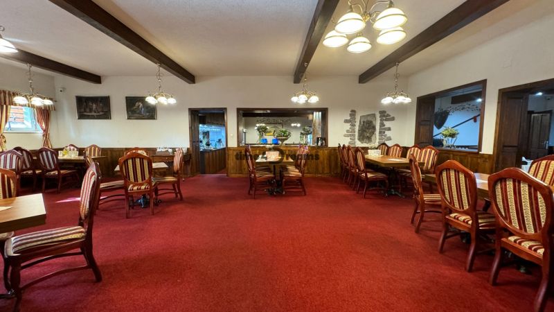 NA PREDAJ hotel s reštauráciou - Reštaurácia s dreveným stropom a červeným kobercom ponúka útulné prostredie pre hostí.