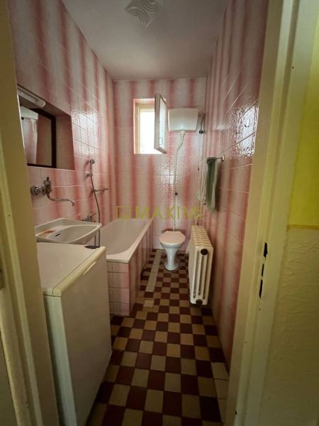 Rodinný dom v Záhorskej Bystrici na ulici Donská - Kúpeľňa s vaňou, umývadlom, práčkou a kockovanou podlahou s dreveným dekorom v rodinnom dome.