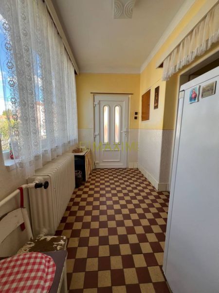 Rodinný dom v Záhorskej Bystrici na ulici Donská - Interiér rodinného domu s kostkovanou podlahou, radiátorom a bielymi záclonami.